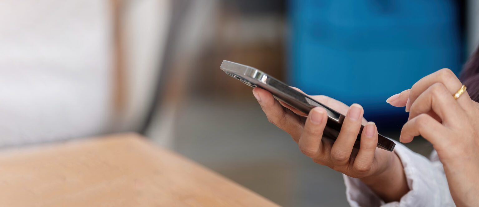 Close up of realtor using cellphone and typing text message on smartphone device because communication your way is the key to keeping you informed throughout the process of selling your home