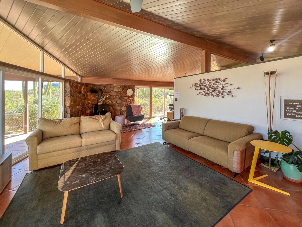 Mid-century modern living room featuring a wood ceiling, strategically placed windows, and timeless design.